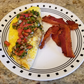 eggs with pico de gallo on a white plate with bacon